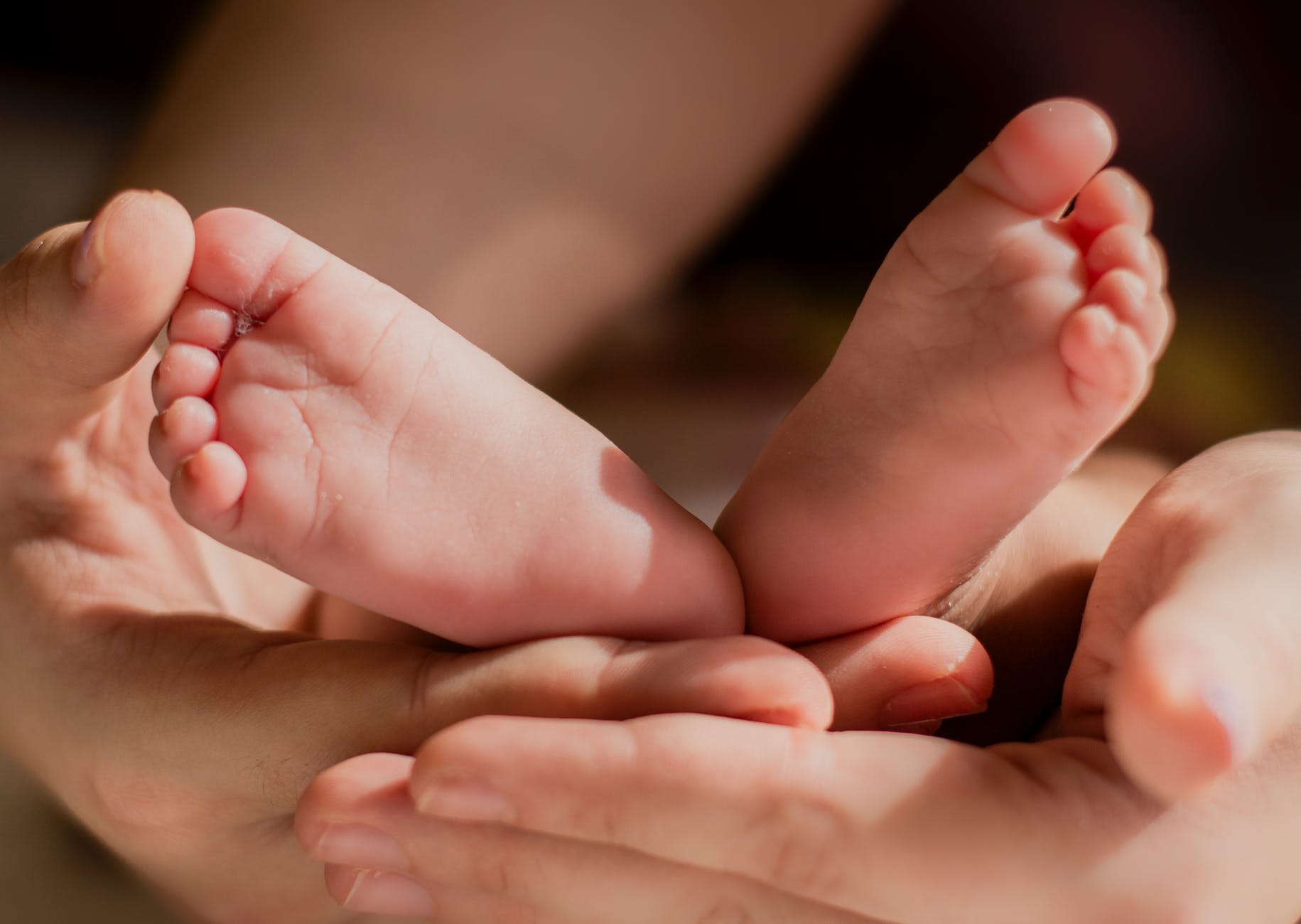 person holding babys feet